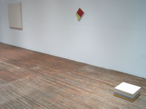 A block sits on the floor next to the items on the walls.