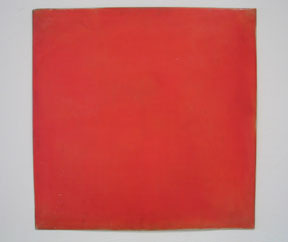 A large red square hanging on a white wall.