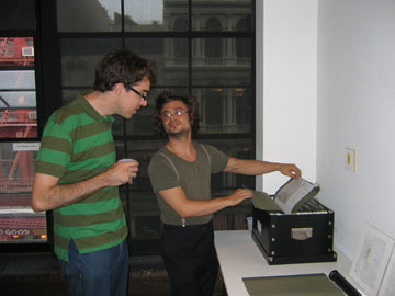 Two people in a room looking through a file.