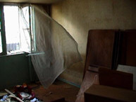 An image of a room with the window curtain billowing in.