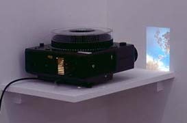 An image of a slides projector playing against a very close wall.