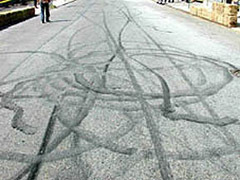 An image of burn-outs from motorcycles on an asphalt road.