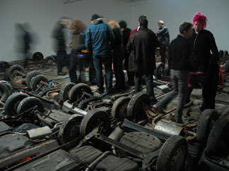 An image of people standing on top of cars at the opening of the show.