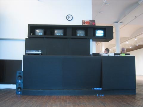 A installation with four different screens, and a person in the background.