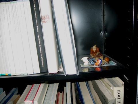 A small sculpture on a bookshelf.