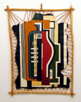 A weaving of abstract shapes hung on a wall.