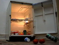 A fridge open with food falling out.