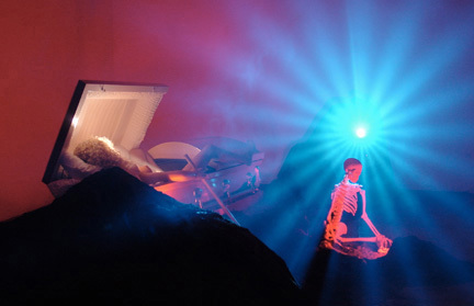 An image of a bright blue light cascading onto a skeleton standing beside a casket.