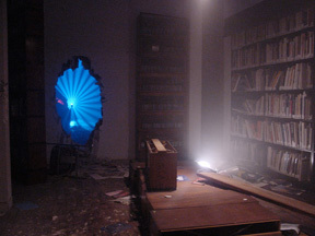 A room with books, a hole, and a light coming from the corner.