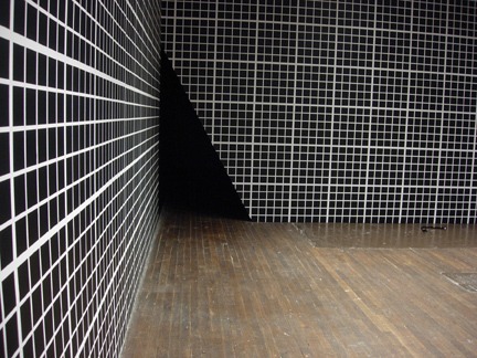 A black and white spotted wall with a black triangle in the corner.