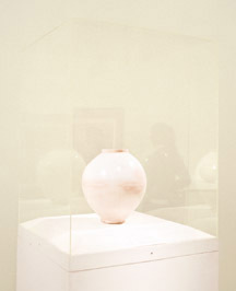 An image of a cream colored vase surrounded by cream walls.