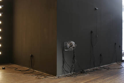 A room with lots of small lights coming from the walk, and sculptural works also coming from the wall.