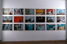 An image of various photographs being hung on a white wall.
