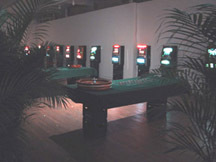 An image of a darkly-lit casino with palm leaves in the foreground.
