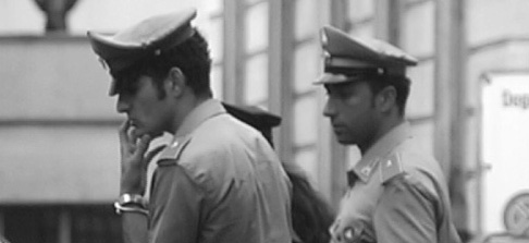 An image of two people in officer uniforms looking out of frame to the left.