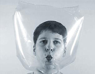 A black and white image of a person with a bag over their head, holding their breath.