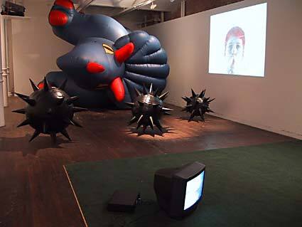 A closer view of the various sculptural and video installations in the gallery.