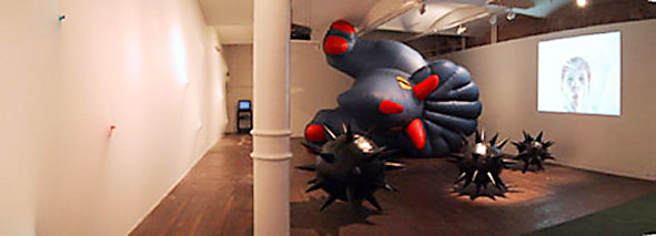 A panoramic view of the exhibition including sculptural and video installations.