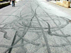An image of Various patterns made on the street from  motorcycle burnouts.