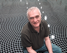 An image of a man sitting on patterned floor, smiling at the camera.